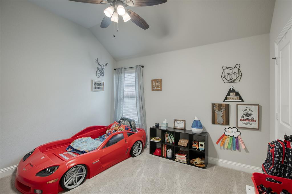 211 Rees Avenue Godley, TX 76044 - Photo 14 of 18 a bedroom with a bed and a chandelier