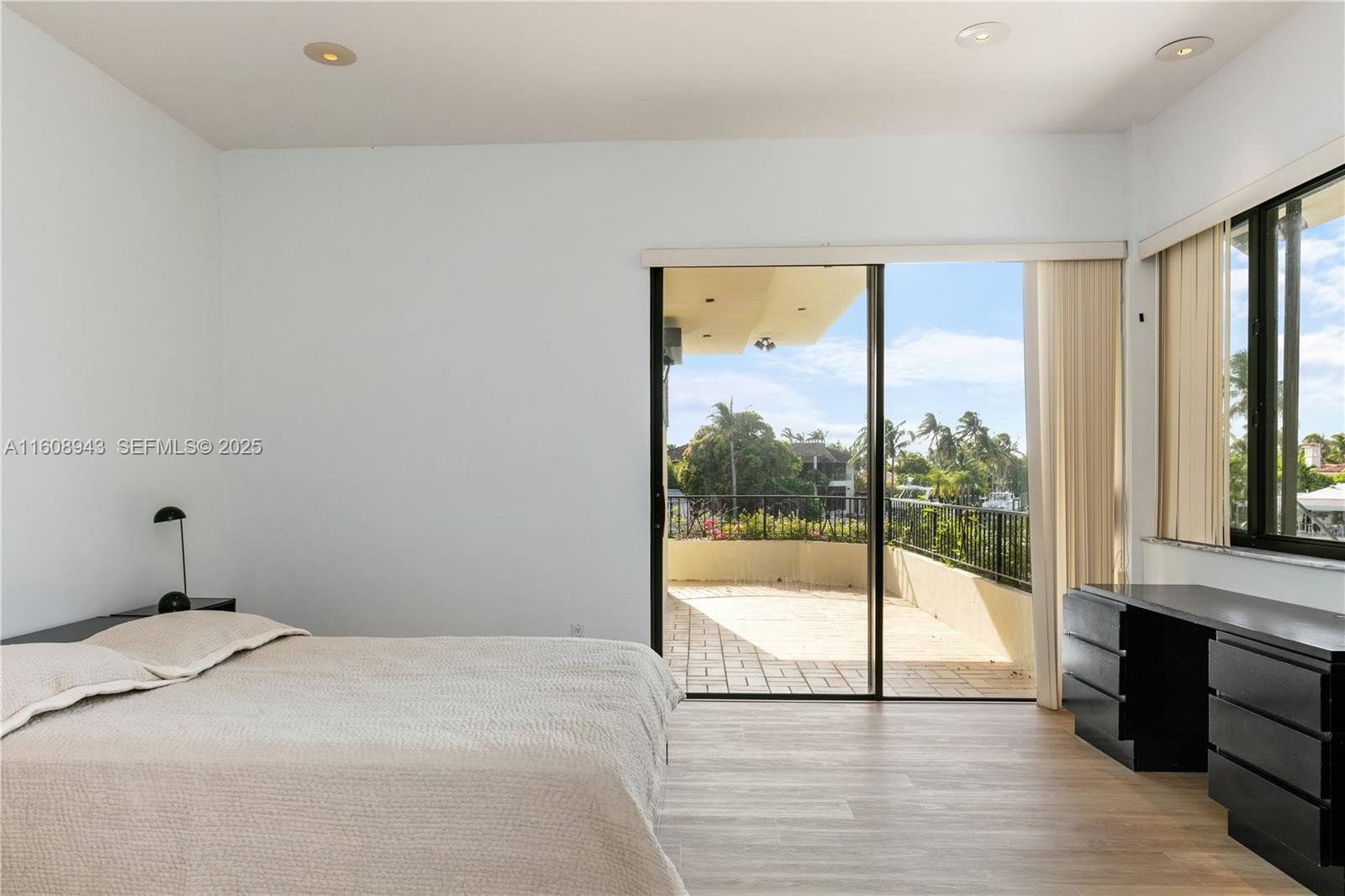 241 Cape Florida Drive Key Biscayne, FL 33149 - Photo 71 of 100 a bedroom with a bed and glass door