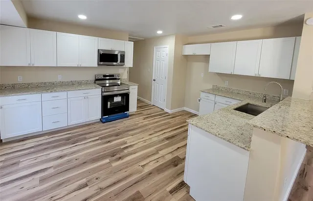a kitchen with granite countertop a sink and a stove top oven