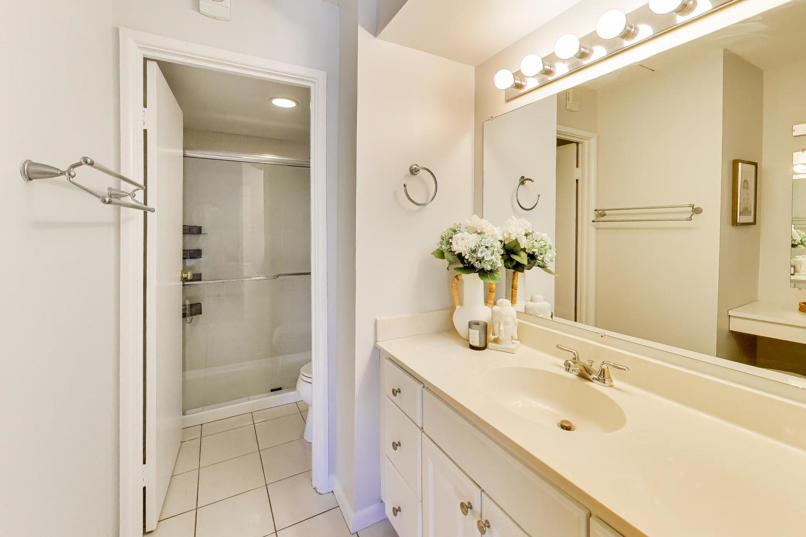 1625 Sheridan Road, Unit 213 Wilmette, IL 60091 - Photo 12 of 18 a bathroom with a tub sink shower and a mirror