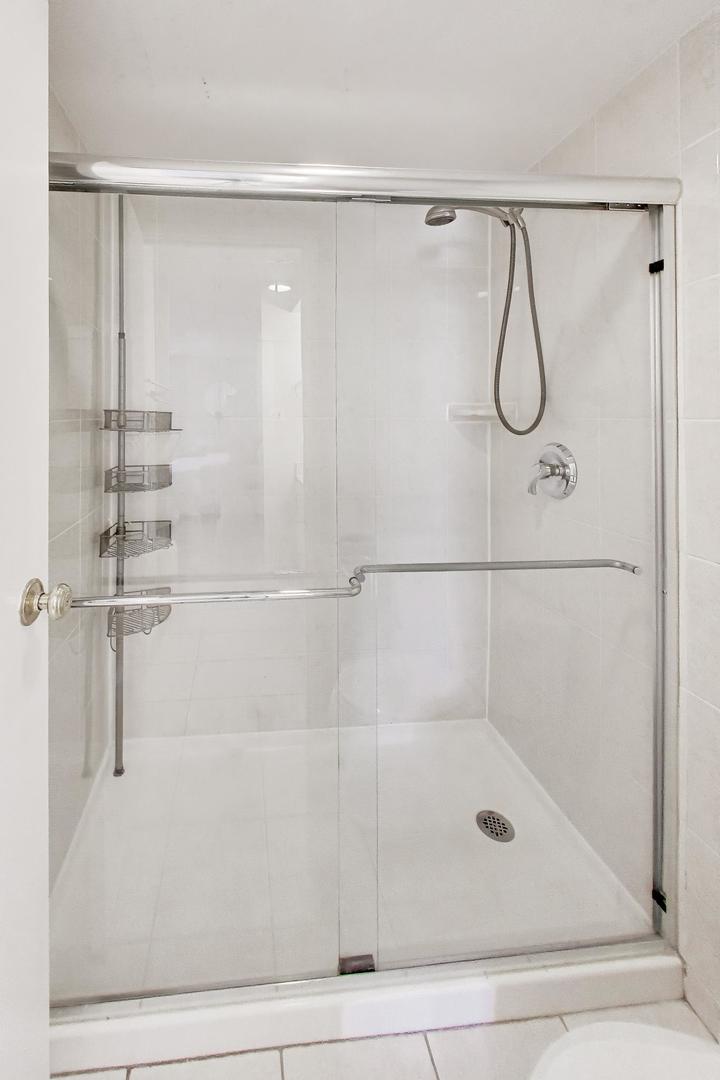1625 Sheridan Road, Unit 213 Wilmette, IL 60091 - Photo 13 of 18 a bathroom with a glass shower door