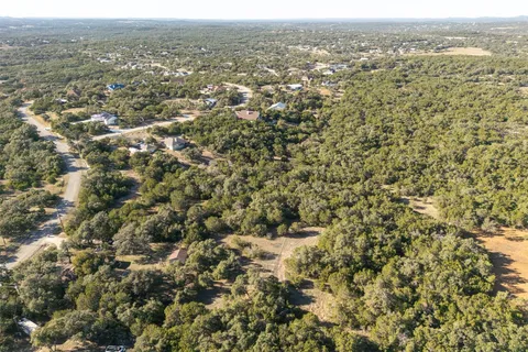 an aerial view of house with yard and mountain view in back