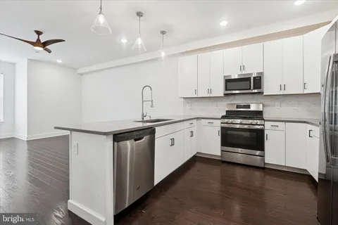 a kitchen with stainless steel appliances white cabinets and a sink
