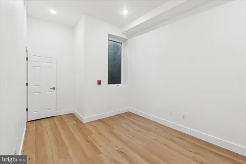 a view of a room with wooden floor and white walls