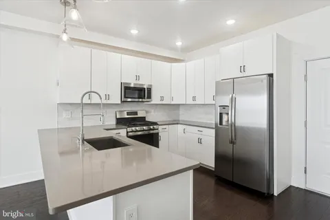 a kitchen with stainless steel appliances a refrigerator sink and microwave