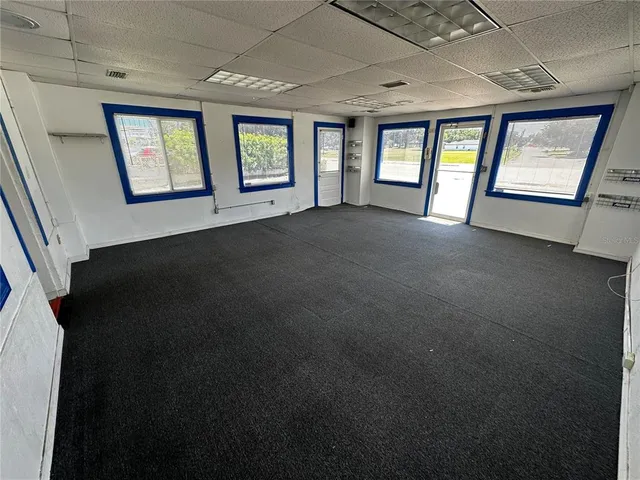 a view of an empty room with windows and closet