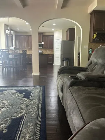 a kitchen with stainless steel appliances wooden floors wooden cabinets dining table and chair