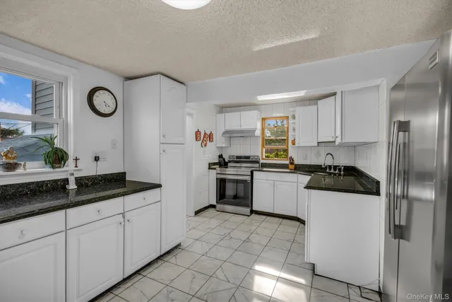 a kitchen with a sink a stove and cabinets