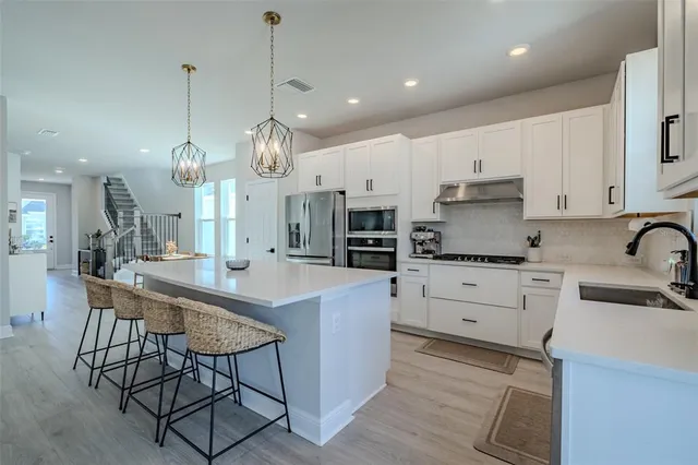 a kitchen with granite countertop white cabinets and white appliances