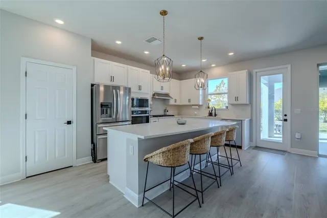 a kitchen with stainless steel appliances granite countertop a sink a stove and a refrigerator