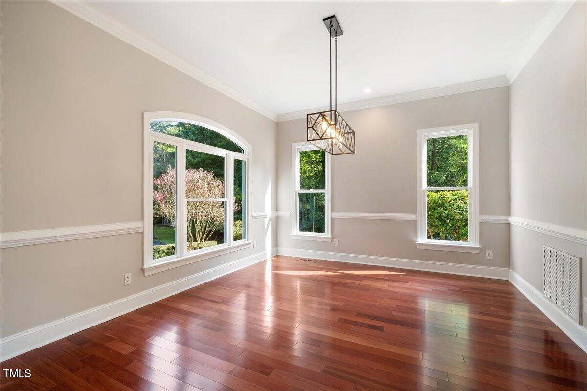 6300 Swallow Cove Lane Raleigh, NC 27614 - Photo 4 of 67 a view of an empty room with wooden floor and a window