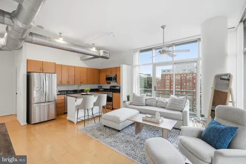 a living room with furniture kitchen and a large window