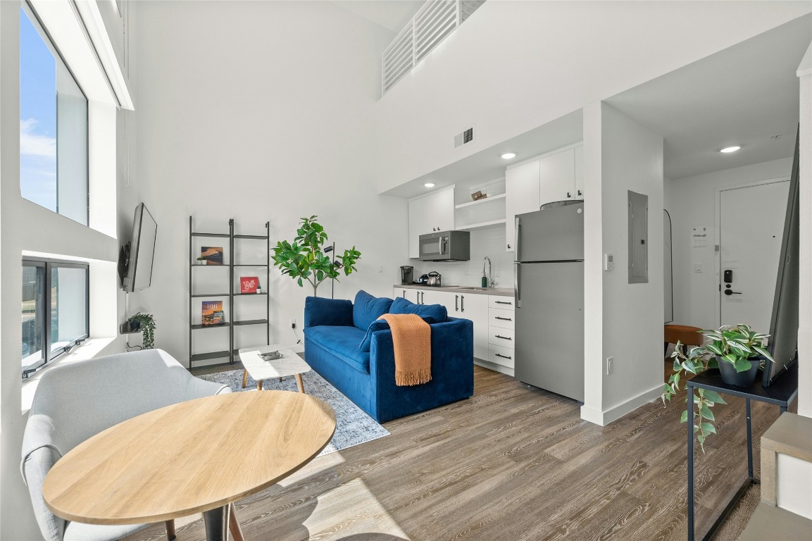 49 Navasota Street, Unit 214 Austin, TX 78702 - Photo 11 of 37 a living room with furniture kitchen view and a fireplace
