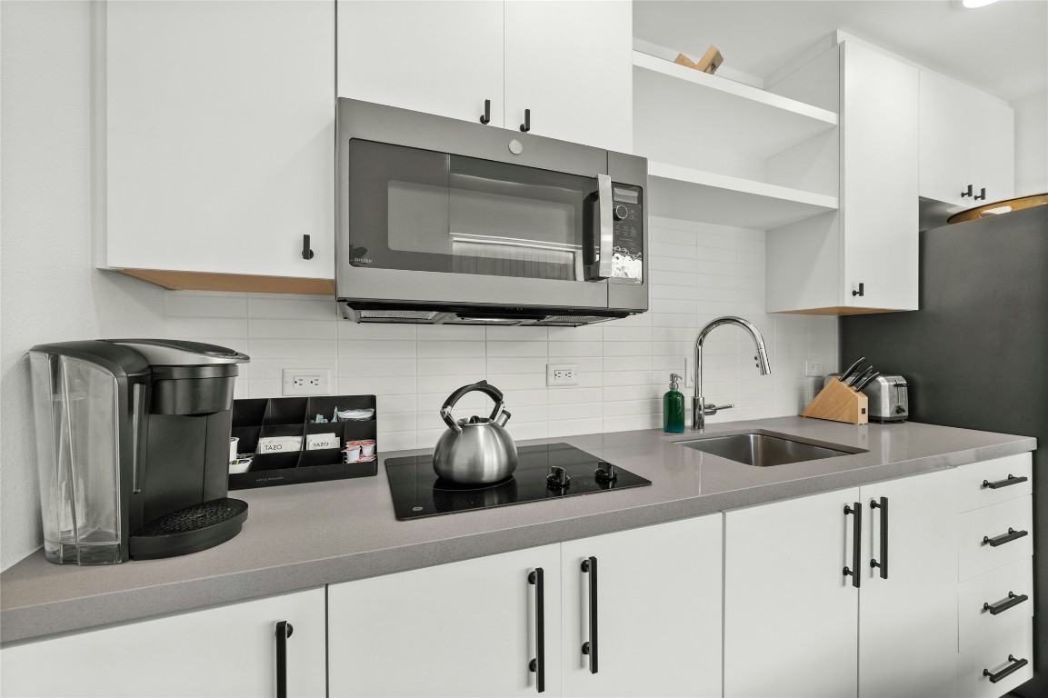 49 Navasota Street, Unit 214 Austin, TX 78702 - Photo 23 of 37 a kitchen with sink a microwave and cabinets
