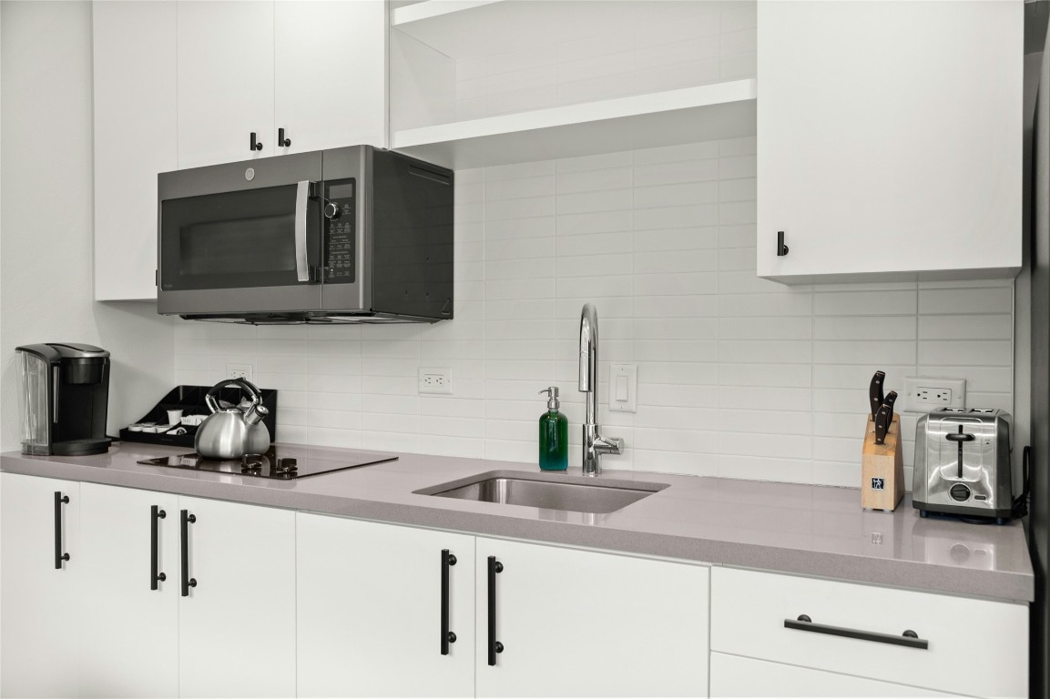 49 Navasota Street, Unit 214 Austin, TX 78702 - Photo 24 of 37 a kitchen with stainless steel appliances a sink a stove a microwave a sink and cabinets