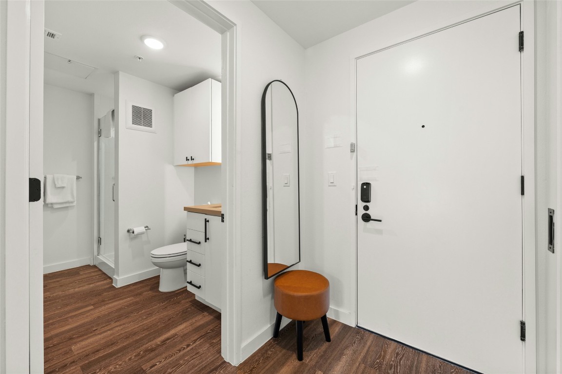49 Navasota Street, Unit 214 Austin, TX 78702 - Photo 27 of 37 a view of a bathroom with a toilet and a mirror