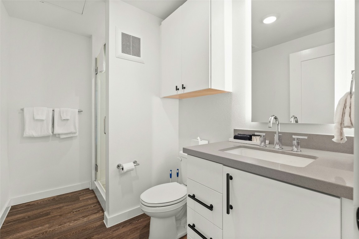 49 Navasota Street, Unit 214 Austin, TX 78702 - Photo 28 of 37 a bathroom with a granite countertop sink mirror vanity and toilet