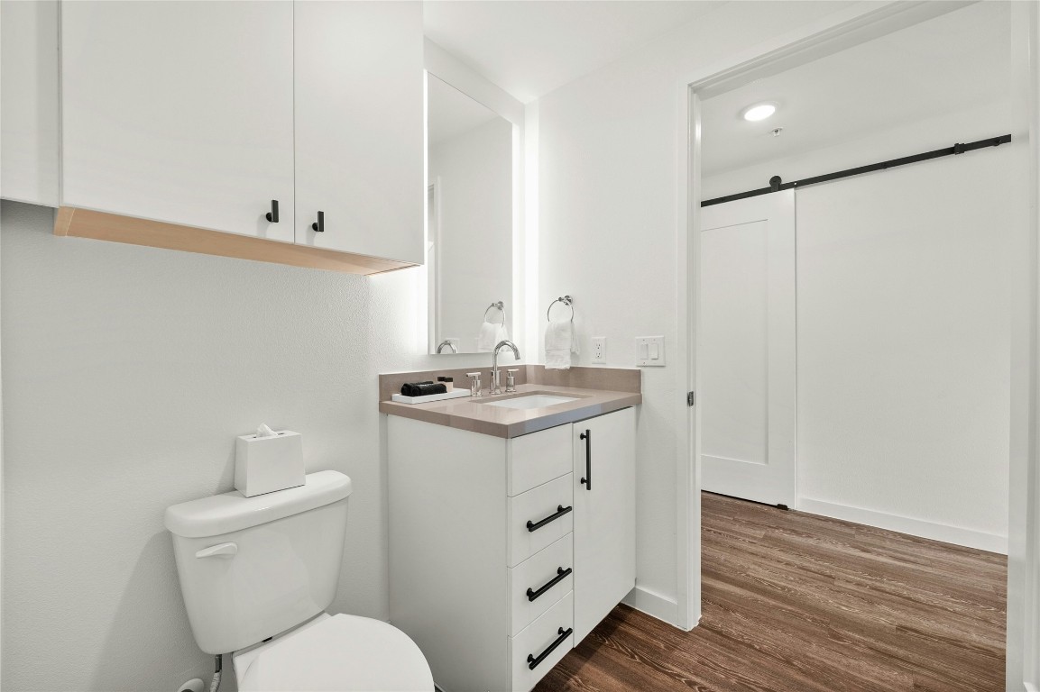 49 Navasota Street, Unit 214 Austin, TX 78702 - Photo 29 of 37 a bathroom with a toilet sink and mirror