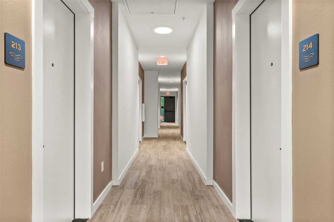 49 Navasota Street, Unit 214 Austin, TX 78702 - Photo 9 of 37 a view of a hallway with wooden floor