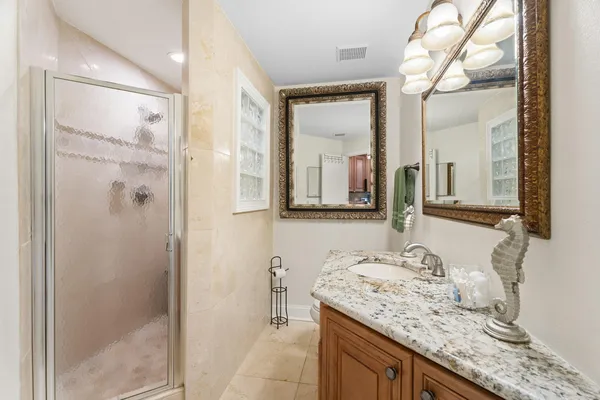 a bathroom with a granite countertop sink and a mirror