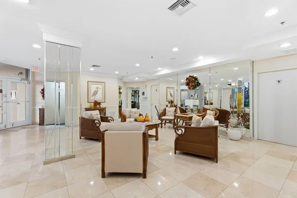 a living room with couches and kitchen view with wooden floor