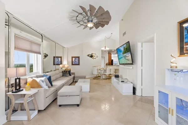 a living room with furniture chandelier and a flat screen tv