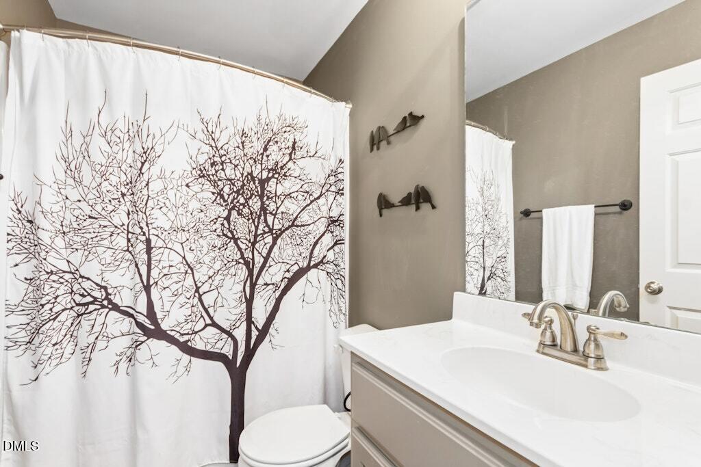 1052 Aquilla Road Benson, NC 27504 - Photo 26 of 31 a bathroom with a toilet sink and mirror
