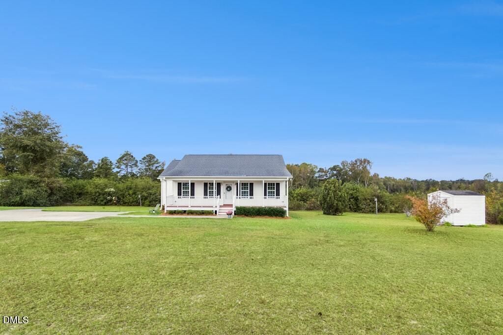 1052 Aquilla Road Benson, NC 27504 - Photo 3 of 31 a front view of a house with a garden