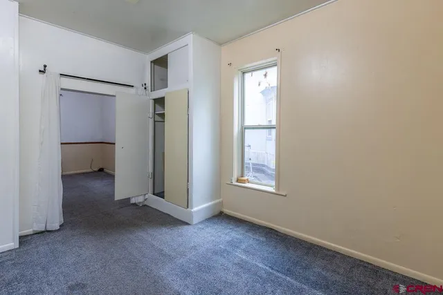 an empty room with windows and closet