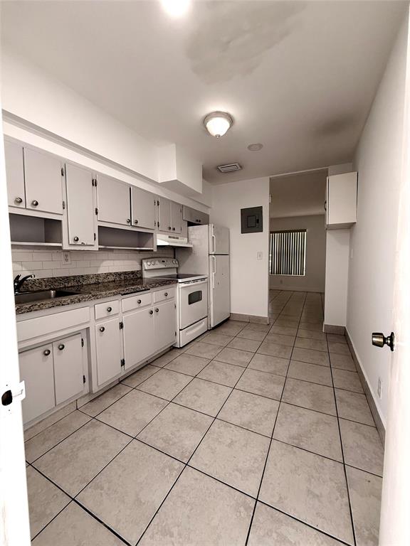 2671 Northeast 18th Terrace Lighthouse Point, FL 33064 - Photo 2 of 7 a kitchen with stainless steel appliances granite countertop a stove a sink and white cabinets
