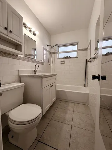 a bathroom with a toilet a sink a mirror and vanity