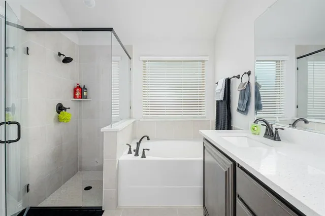 a bathroom with a tub sink and mirror