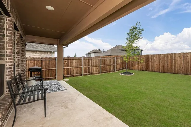 a view of a backyard with table and chairs and wooden fence