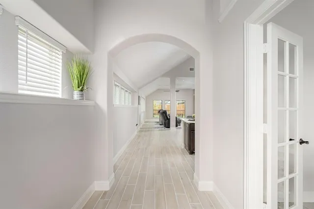 a view of a hallway with wooden floor and a living room