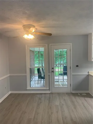 a large white kitchen with a sink and dishwasher a stove top oven with wooden floor