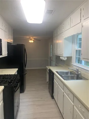 a kitchen with granite countertop white cabinets and stainless steel appliances