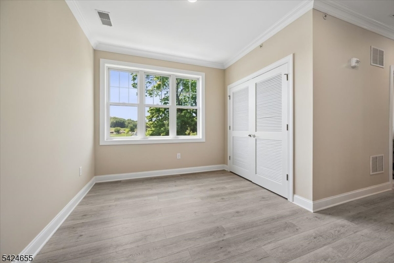 401 Mariners Pointe Hopatcong, NJ 07843 - Photo 23 of 42 an empty room with wooden floor and windows