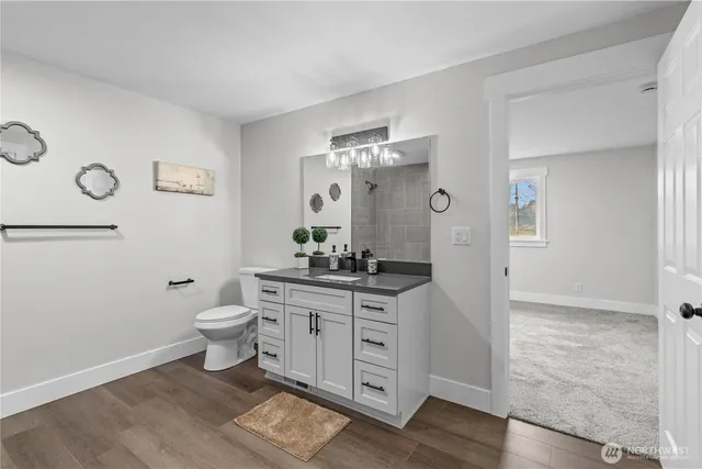 a bathroom with a granite countertop sink a toilet and shower