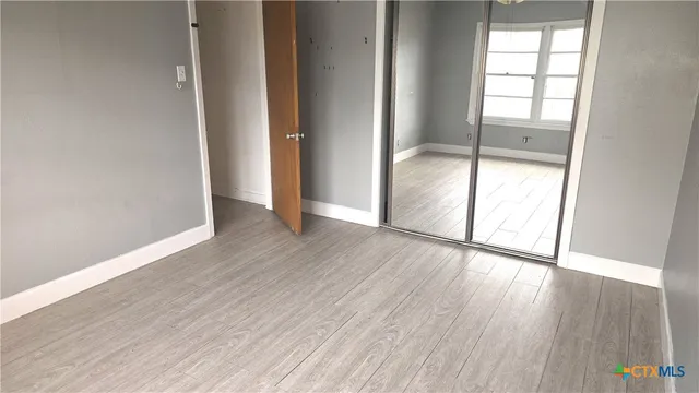 an empty room with a window and a fan