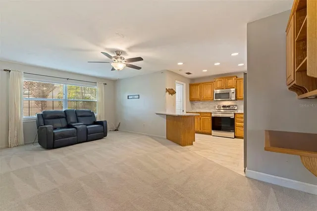 a living room with furniture kitchen view and a window