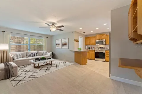 a living room with furniture kitchen view and a large window