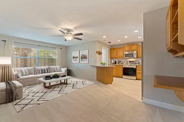 a living room with furniture kitchen view and a large window