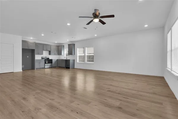 a view of empty room with wooden floor and window