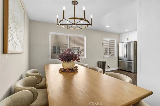 a dining room with stainless steel appliances kitchen island granite countertop furniture a rug and a window