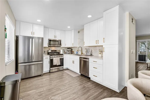 a kitchen with white cabinets and stainless steel appliances
