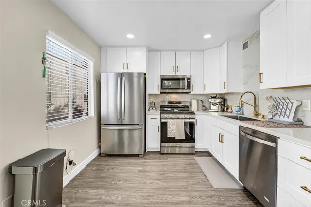 a kitchen with stainless steel appliances a refrigerator sink and microwave