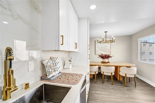 a kitchen with stainless steel appliances granite countertop a stove top oven a dining table and chairs with wooden floor