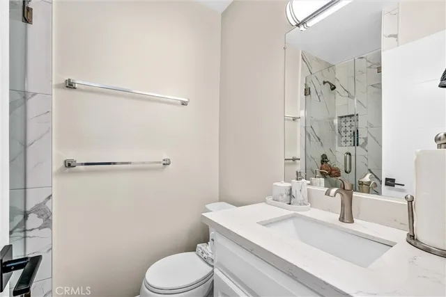 a bathroom with a sink toilet vanity and shower