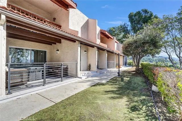 a backyard of a house with barbeque oven and outdoor seating