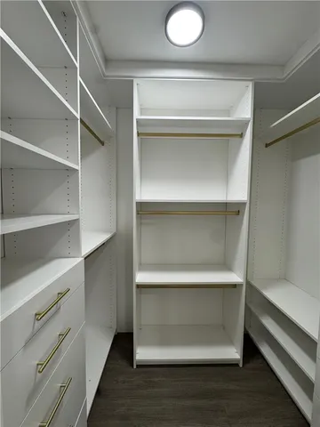 a view of walk in closet with empty racks
